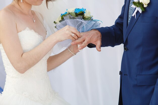 Les nouveaux mariés avec des anneaux sur les doigts au jour du mariage.