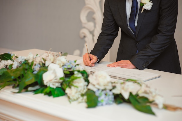 Les nouveaux mariés apposent leur signature sur l'acte d'enregistrement d'un mariage