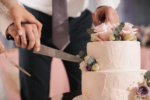 Les nouveaux mariés coupent le gâteau au mariage