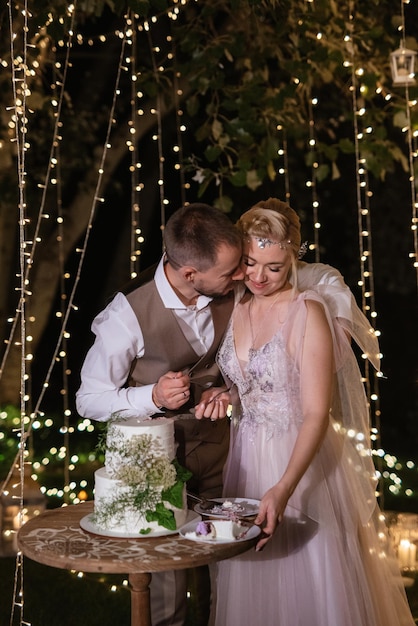 Les Nouveaux Mariés Coupent Joyeusement Le Rire Et Goûtent Le Gâteau De Mariage