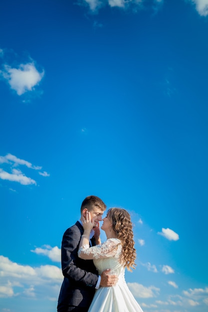 Les nouveaux mariés sur le mur de ciel bleu.Photo de mariage.