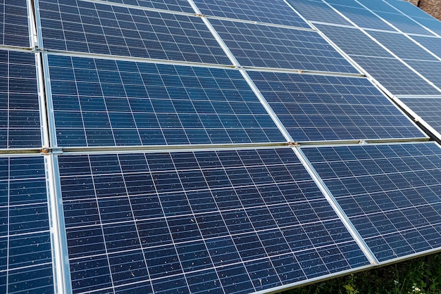 De nouveaux panneaux solaires sont posés sur le sol recouvert d'herbe Concept d'électricité verte