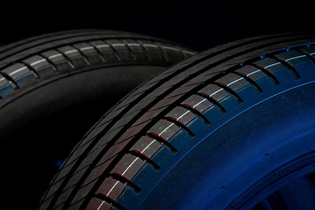 Nouveaux pneus de voiture Groupe de roues de route sur fond sombre Pneus d'été avec bande de roulement asymétrique Conduite concept de voiture