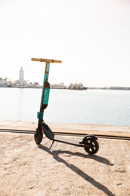Photo nouveaux scooters électriques garés près du quai contre la mer idyllique
