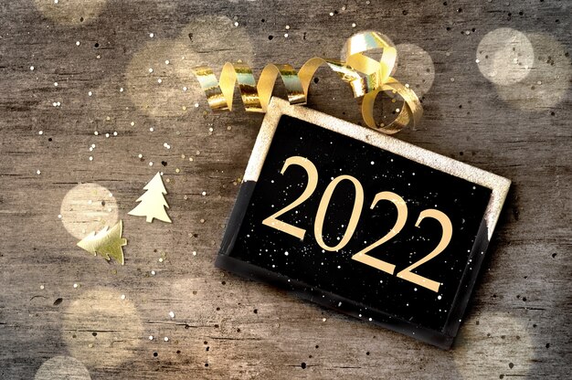 Nouvel an 2022 écrit le petit signe sur la décoration de Noël sur fond de bois