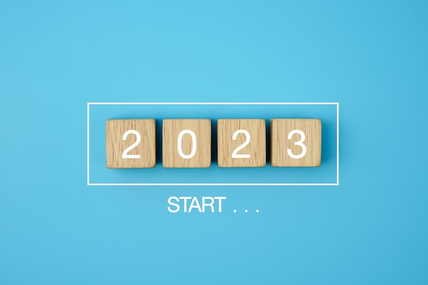 Nouvel an 2023. Commencez la nouvelle année 2023 avec un plan d'objectifs, une barre de progression avec des blocs de bois 2023 sur bleu