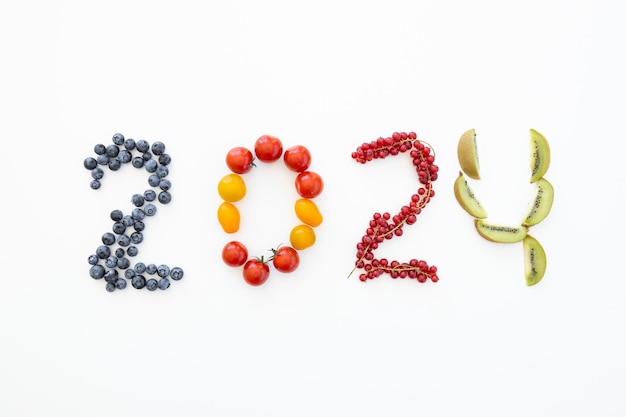 Nouvel an 2024 fait de fruits sur fond blanc Alimentation saine