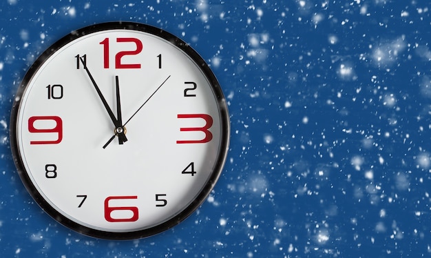 Le nouvel an arrive. Grande horloge murale sur fond bleu classique. Joyeux Noël et bonne année carte de voeux sur fond bleu neige avec espace de copie. La nouvelle tendance couleur de l'année 2020