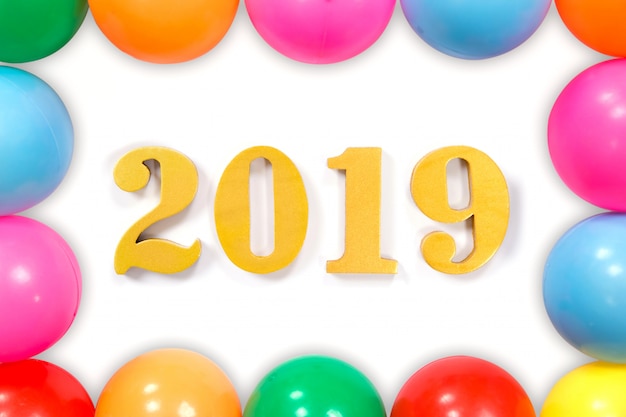 Nouvel an Concept.Word 2019 mis sur le fond blanc et les boules colorées portant autour.