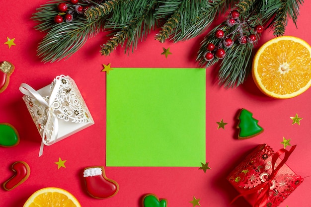 Nouvel An Flatlay branches de sapin baies rouges cadeau orange papier vert pour écrire au centre