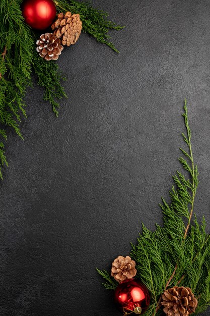 Photo nouvel an ou fond sombre de noël décoré de jouets, de pommes de pin et de branches de sapin