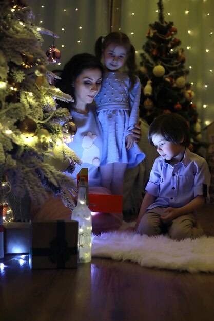 Nouvel An La maison est décorée pour les vacances Arbre de Noël habillé avec élégance avec une guirlande et une famille avec des cadeaux et une surprise