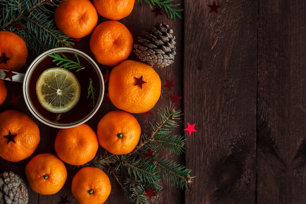 Nouvel an de Noël avec des mandarines, du thé et des bonbons sur la table. hiver encore. mise au point sélective. fond