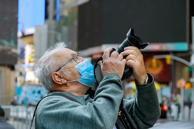 Un nouvel homme du tourisme normal dans un masque prend des photos de New York Travel City Tour pendant les vacances d'été après le verrouillage USA