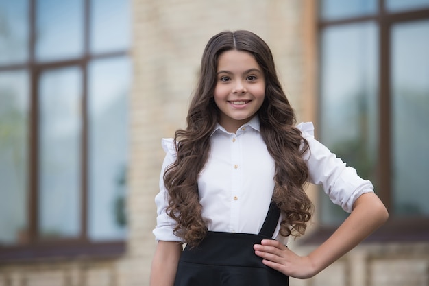 Nouvelle année scolaire. Bonne écolière à l'extérieur. Petite fille de retour à l'école. Uniforme de mode pour les filles. L'éducation formelle. Enseignement privé. 1er septembre. Journée du savoir.