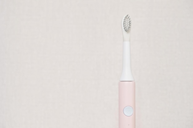 Nouvelle brosse à dents à ultrasons moderne. Modèle de mâchoire et fournitures de soins dentaires sur fond gris. Hygiène bucco-dentaire, santé dentaire et gingivale, dents saines. Produits dentaires Brosse à dents à vibration ultrasonique.