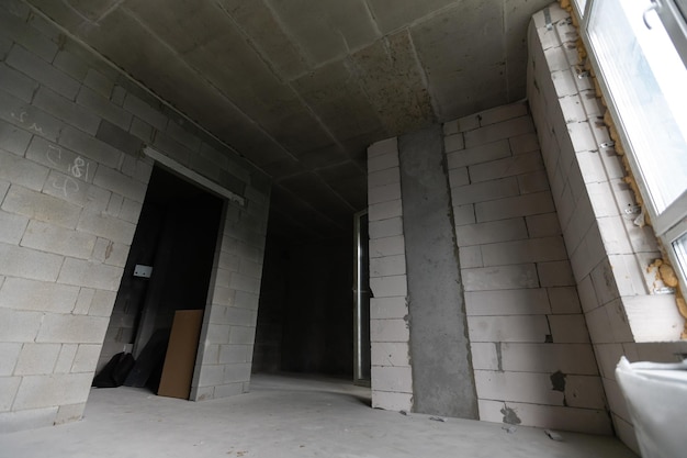 Une nouvelle chambre d'appartement inachevée aux murs de briques nues sans décoration.