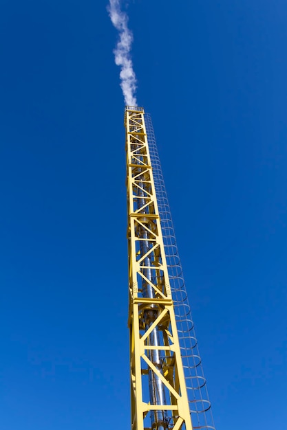 Une nouvelle chaufferie de travail jaune à l'extérieur par une belle journée ensoleillée Carburant moderne et pollution de l'environnement