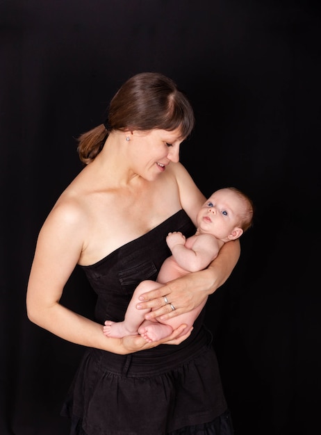 Une nouvelle maman passe du temps de qualité avec son petit garçon, une maman joyeuse portant un bébé