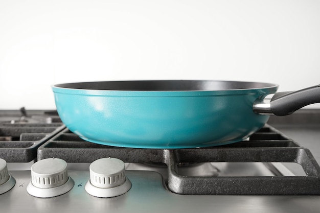 Nouvelle poêle bleue sur la cuisinière à gaz Gros plan