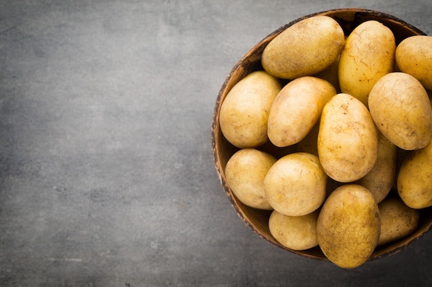 Nouvelle pomme de terre sur le bol, fond gris.