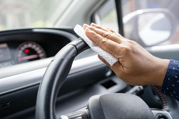 Une nouvelle travailleuse asiatique normale nettoie dans la voiture pour protéger la sécurité Coronavirus