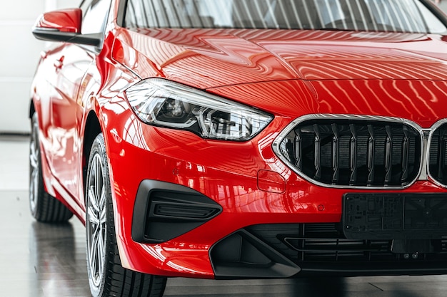 Nouvelle voiture de luxe rouge sur une présentation de voiture dans la salle d'exposition de voiture