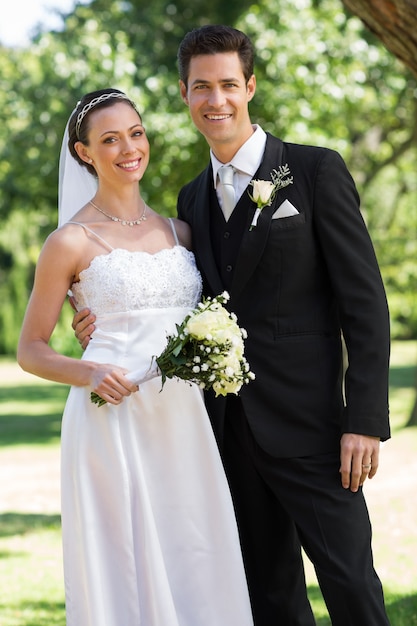 Nouvellement marié couple debout dans le jardin