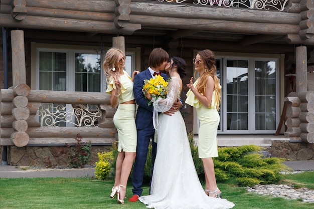 Nouvellement marié avec des demoiselles d'honneur lors d'une cérémonie de mariage à la villa