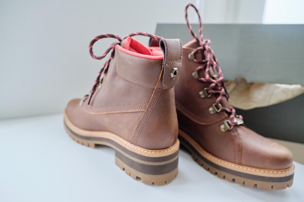 Nouvelles bottes d'automne d'hiver de randonnée imperméables en cuir marron pour femme dans une boîte, chaussures à la mode pour l'hiver. Déballer des bottes, faire des achats en ligne depuis chez soi, magasin de mode de chaussures