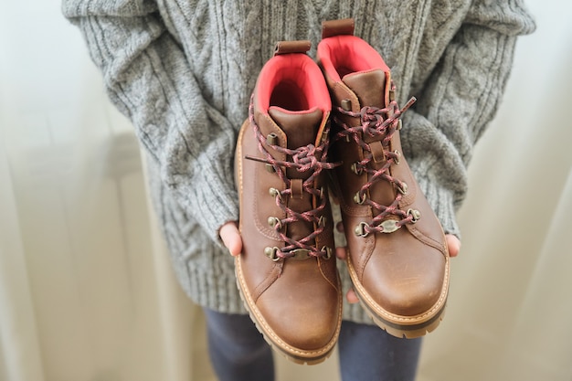 Nouvelles bottes d'automne d'hiver de randonnée imperméables en cuir marron pour femmes dans les mains de chaussures féminines à la mode pour l'hiver. Déballage des chaussures, achats en ligne à domicile, magasin de mode de chaussures