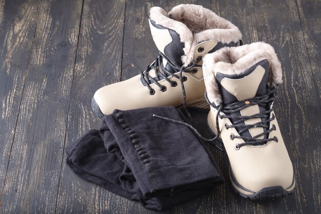 Nouvelles bottes d'hiver féminines sur plancher en bois et collants chauds. Prêt pour le temps froid