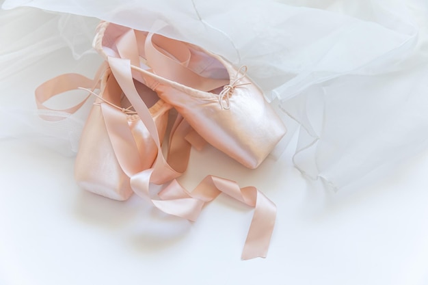 Photo nouvelles chaussures de ballet beige pastel avec un ruban de satin et une jupe tutut isolée sur fond blanc