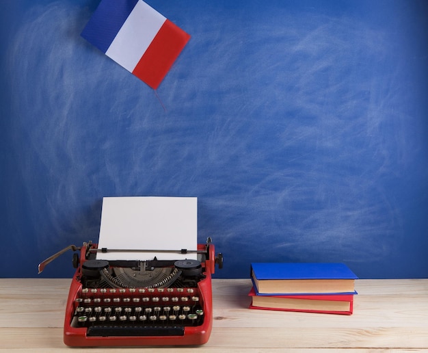 Photo nouvelles politiques et concept d'éducation drapeau de machine à écrire rouge de la france livres sur table