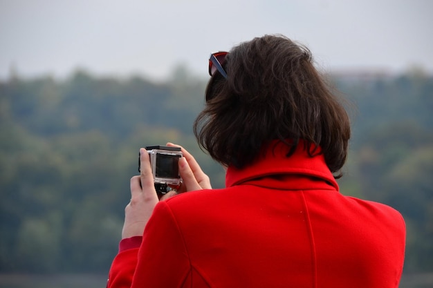 Novi Sad Serbie 24 octobre 2015 Femme en manteau rouge prenant une photo avec une caméra d'action