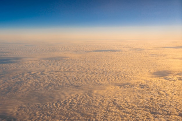 Nuage doré sur le ciel bleu Côté extérieur au-dessus de la vue depuis les fenêtres latérales de l'avion au lever du soleil,