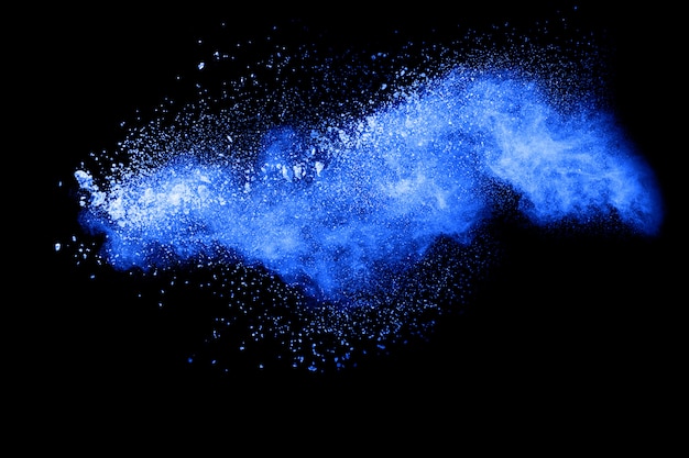 Nuage d&#39;explosion de poudre de couleur bleue sur fond noir. Gros plan des particules de poussière bleu expirent sur fond sombre.