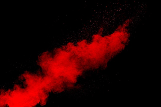 Nuage d'explosion de poudre rouge sur fond noir Figer le mouvement des éclaboussures de particules de poussière de couleur rouge