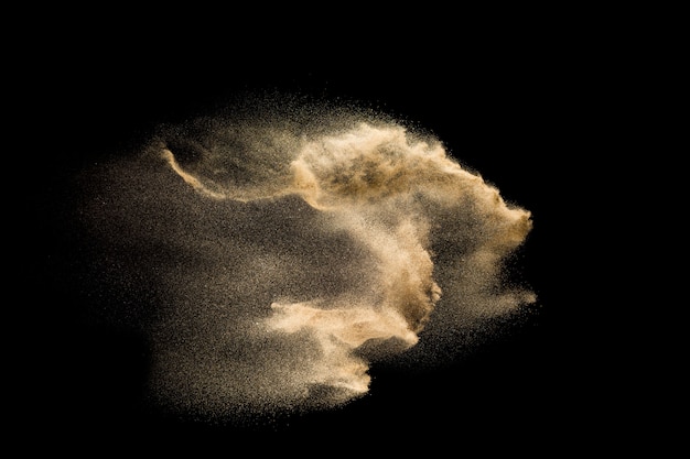 Nuage de sable abstrait. Éclaboussure de sable doré sur fond sombre.