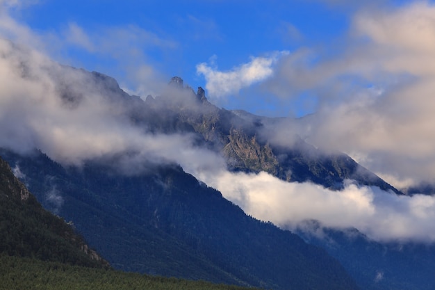 Nuages au-dessus des montagnes rocheuses recouvertes d'arbres photographiés dans le Caucase Russie