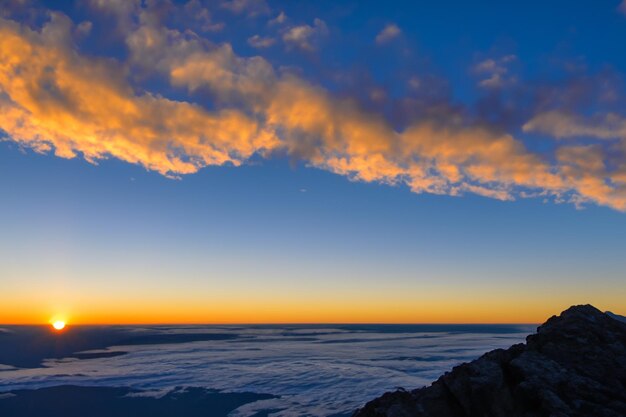 les nuages au dessus des montagnes sont magnifiques avec un lever de soleil et une ambiance très harmonieuse