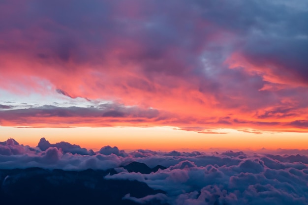 les nuages au dessus des montagnes sont magnifiques avec un lever de soleil et une ambiance très harmonieuse