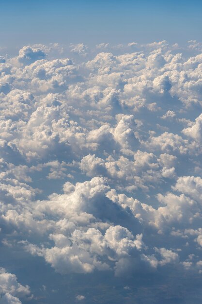 Nuages blancs et ciel bleu, vue depuis la fenêtre de l'avion. Fond de nature