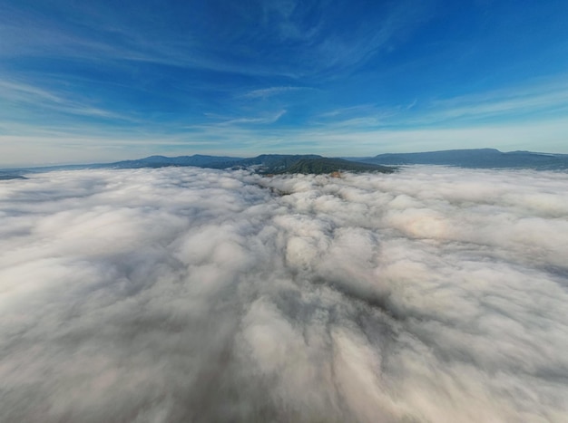 Nuages et ciel au-dessus de la montagne depuis la fenêtre de l'avion, vue aérienne pour les arrière-plans de la nature du matin