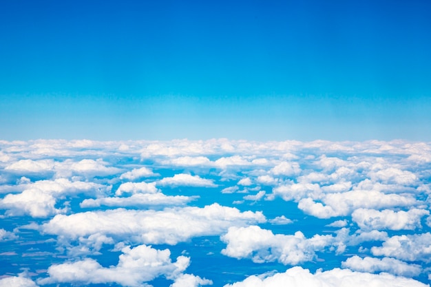 Nuages et ciel vus à travers la fenêtre d'un avion