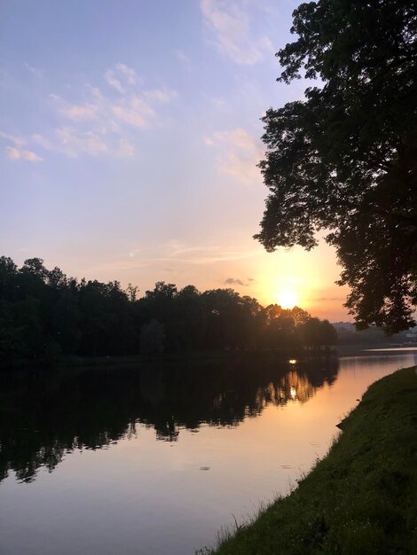 Des nuages dramatiques au coucher du soleil sur le lac et les arbres photo de stock