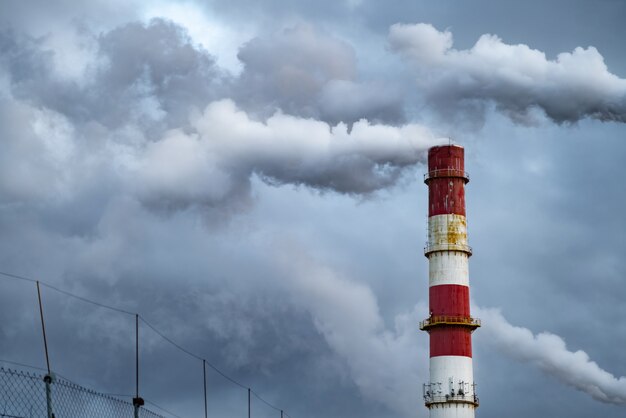 Nuages de fumée toxiques sombres sortant de la cheminée de l'usine.