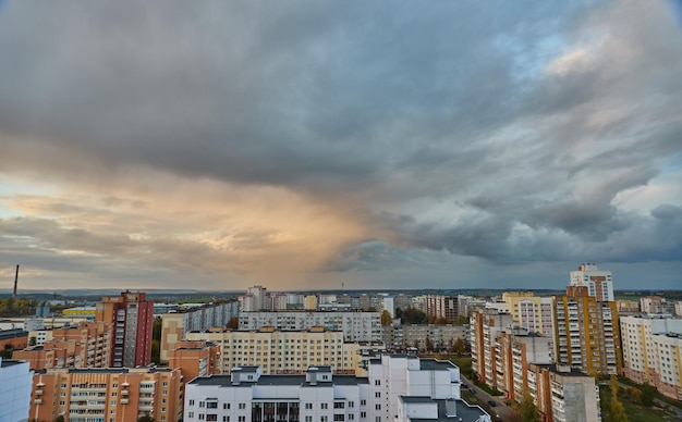 Des nuages multicolores inhabituels au-dessus de la ville au coucher du soleil Des nuages au-dessus des immeubles résidentiels de grande hauteur