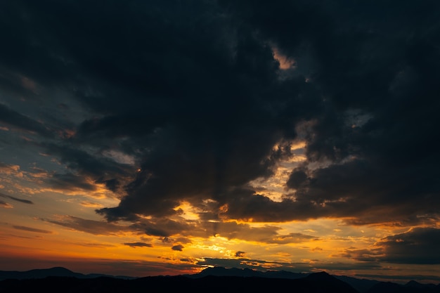 Nuages noirs sombres et coucher de soleil orange ardent