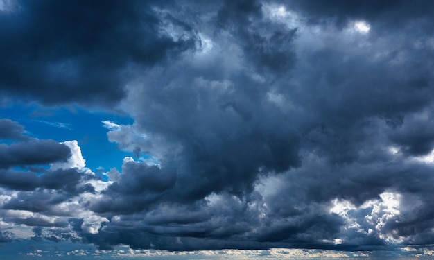 Nuages d'orage et rayons du soleil sur fond sombre